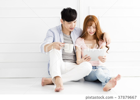 young couple sitting together and looking tablet young couple sitting together and looking tablet 37879667