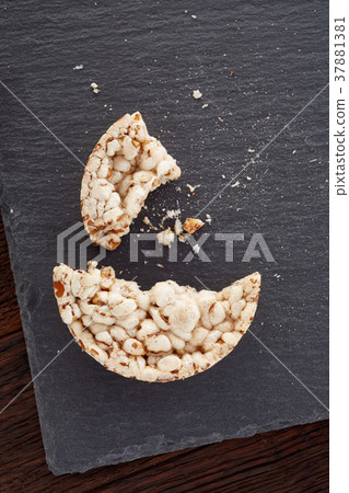 Broken crispbread on stone plate. Dark background 37881381