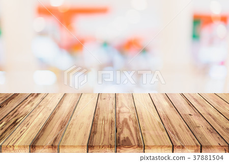 wooden table with blur shopping mall background. 37881504