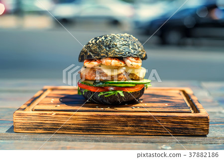 Black burger with prawns on wooden board 37882186