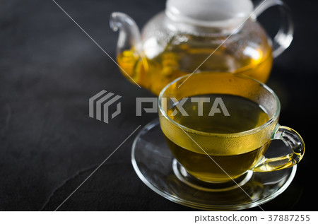 Cup of delicious herbal tea and glass teapot. 37887255