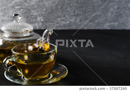 Cup of delicious herbal tea and glass teapot. 37887260