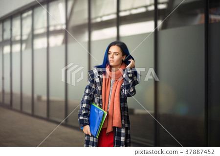 Young student walk by city with blue folder. 37887452