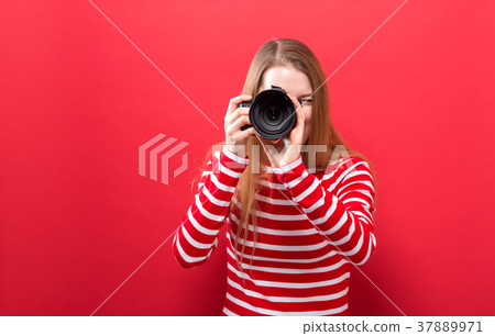 Young woman holding a camera Young woman holding a camera 37889971