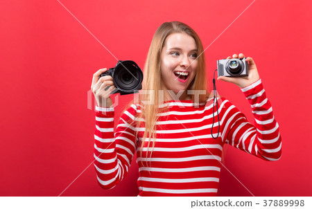 Young woman comparing professional and compact Young woman comparing professional and compact 37889998