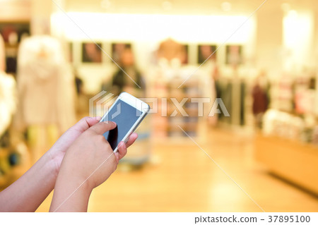 blur smart phone on people walk in shopping mall blur smart phone on people walk in shopping mall 37895100