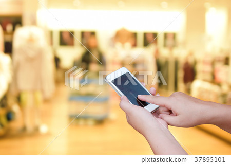 blur smart phone on people  walk in shopping mall 37895101