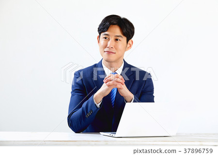 Twenty-something business man sitting and working on a laptop 37896759