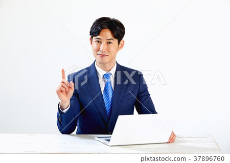 Twenty-something business man sitting and working on a laptop Twenty-something business man sitting and working on a laptop 37896760