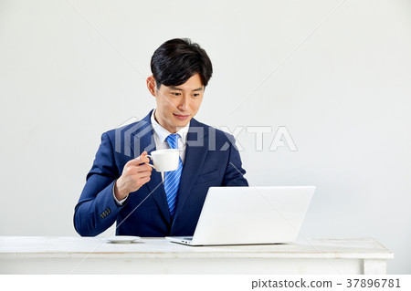 Twenty-something business man sitting and working on a laptop 37896781