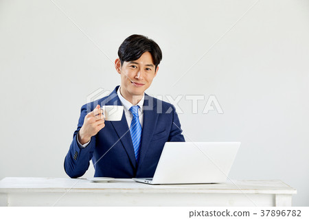 Twenty-something business man sitting and working on a laptop 37896782