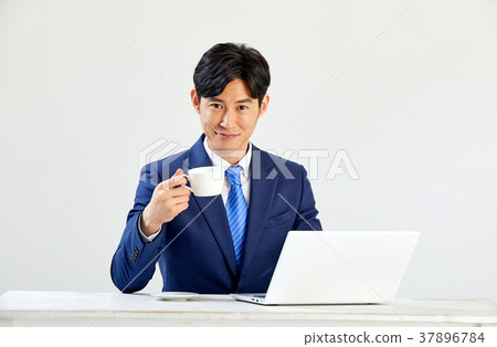 Twenty-something business man sitting and working on a laptop 37896784