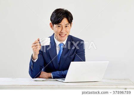 Twenty-something business man sitting and working on a laptop 37896789