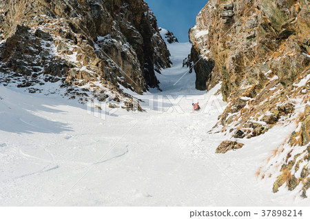 A male skier freerider with a beard descends the A male skier freerider with a beard descends the 37898214