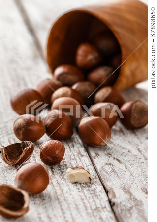 Hazelnut heap on wooden table, selective focus. Hazelnut heap on wooden table, selective focus. 37898650