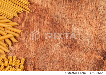 Assortment of different shape pastas on wooden 37898664