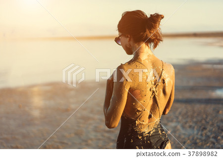 A young woman enjoying the natural mineral mud A young woman enjoying the natural mineral mud 37898982