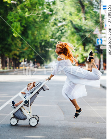 mom with a stroller crosses the road mom with a stroller crosses the road 37899155