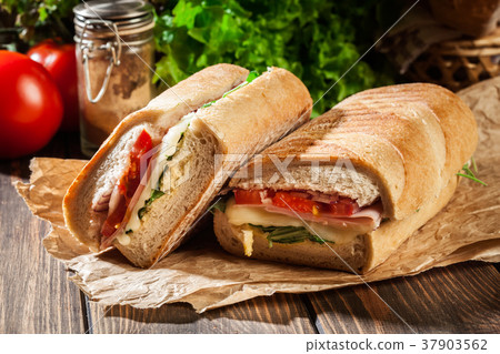 Toasted panini with ham, cheese and arugula Toasted panini with ham, cheese and arugula 37903562