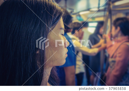 Stressed Asian girl using a smartphone in mass rapid transit amo Stressed Asian girl using a smartphone in mass rapid transit amo 37903838