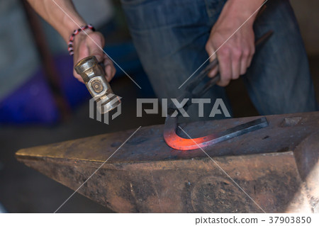 farrier making a traditional horseshoe on a forge farrier making a traditional horseshoe on a forge 37903850