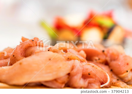 Raw spiced chicken fillet and fresh vegetables Raw spiced chicken fillet and fresh vegetables 37904213