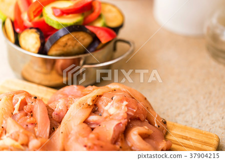 Raw spiced chicken fillet and fresh vegetables Raw spiced chicken fillet and fresh vegetables 37904215
