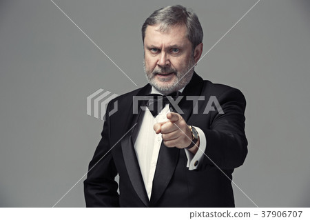 Senior Businessman standing and pointing to camera Senior Businessman standing and pointing to camera 37906707