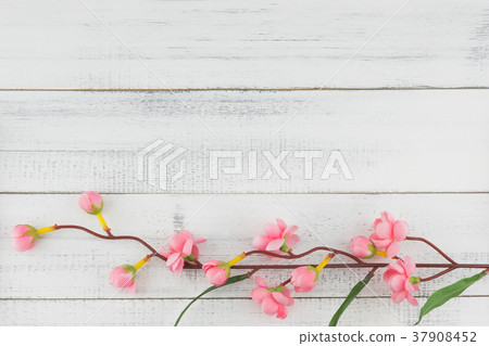 Fake pink flower branches on white wood  37908452