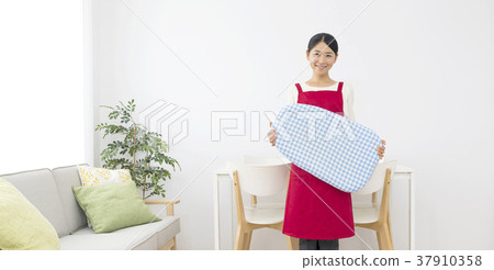 A smiling female apron with an iron A smiling female apron with an iron 37910358