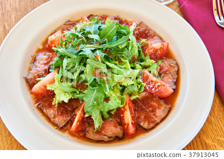 Salad with arugula leaves, fried meat and tomato 37913045