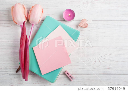 Mint notebook, tulips and lit candle 37914049
