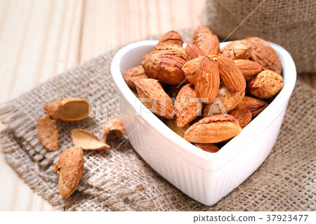 Almond nuts in the shell In a heart shaped bowl  37923477