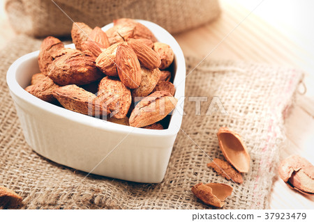 Almond nuts in the shell In a heart shaped bowl 37923479