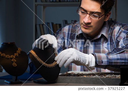 Young male jeweller working at night in his 37925227
