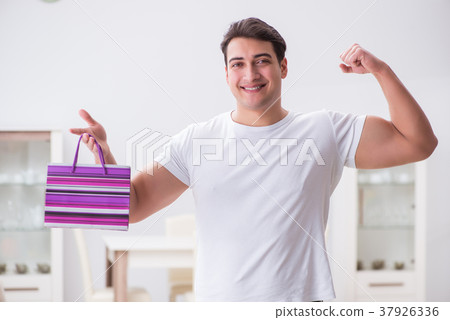 Young man with gift bag at home preparing suprise Young man with gift bag at home preparing suprise 37926336