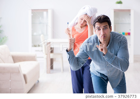 Wife and husband looking at pregnancy test 37926773