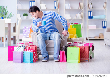 Young man after excessive shopping at home 37926942