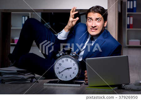 Businessman working overtime long hours late in Businessman working overtime long hours late in 37926950
