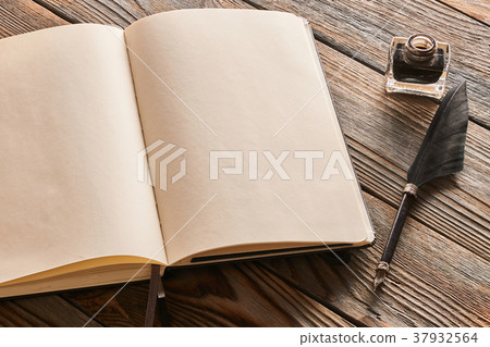 Feather pen and blank notebook page 37932564