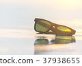 sun glasses on beach and sunset 37938655