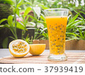 Passion fruits half and juice on green backgroun 37939419