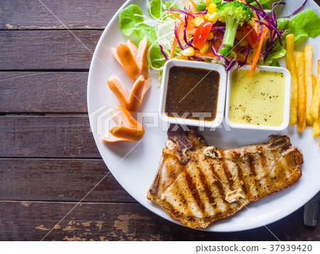 Grilled pork chop steak, French fries and salad  37939420