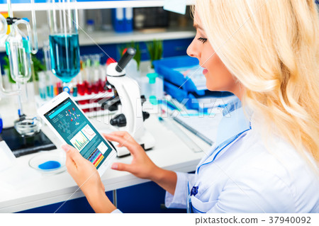 Young attractive woman scientist using tablet computer in the la Young attractive woman scientist using tablet computer in the la 37940092