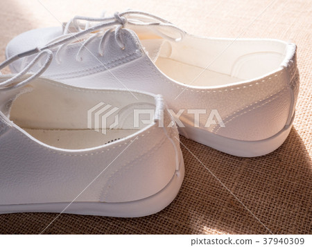 Couple of white shoe on wood background Couple of white shoe on wood background 37940309