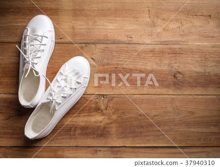 Couple of white shoe on wood background Couple of white shoe on wood background 37940310