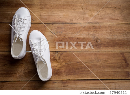 Couple of white shoe on wood background Couple of white shoe on wood background 37940311