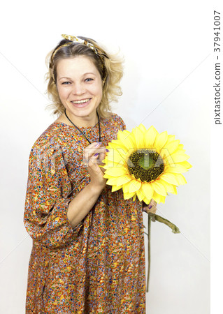 A pregnant woman in a long dress with a big flower. 37941007
