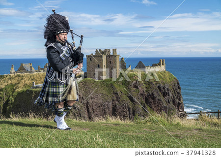 Traditional scottish bagpiper in full dress code 37941328