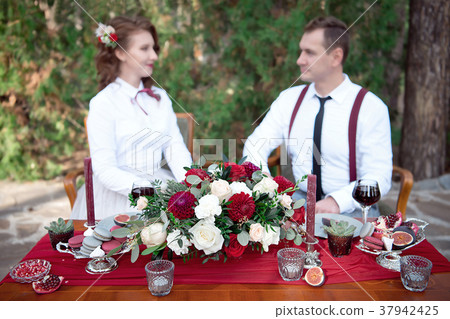 Romantic table with fresh flowers and candles with couple in love on background. Romantic table with fresh flowers and candles with couple in love on background. 37942425
